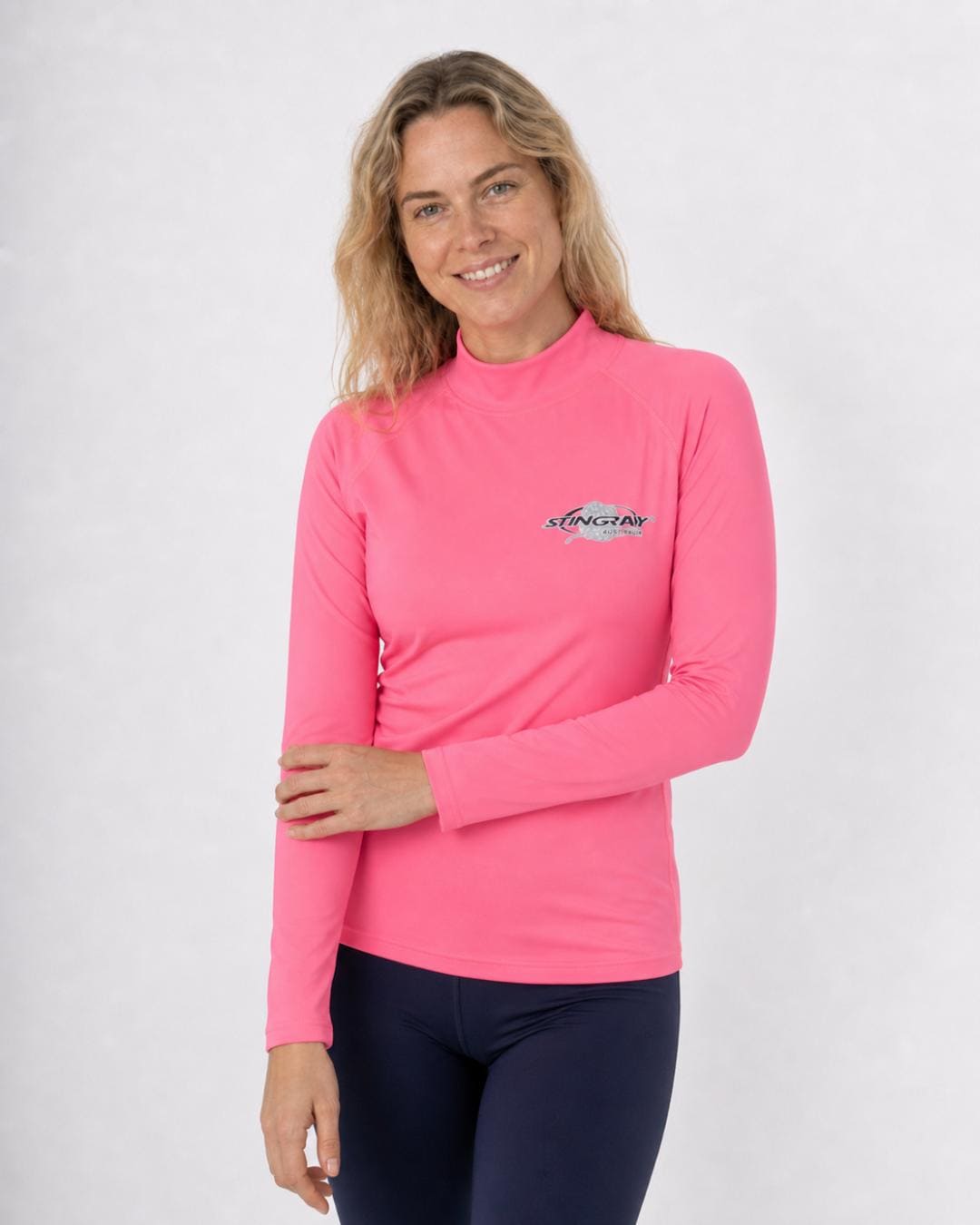 Woman wearing a pink long-sleeve UV rash shirt UPF 50+ on a white background