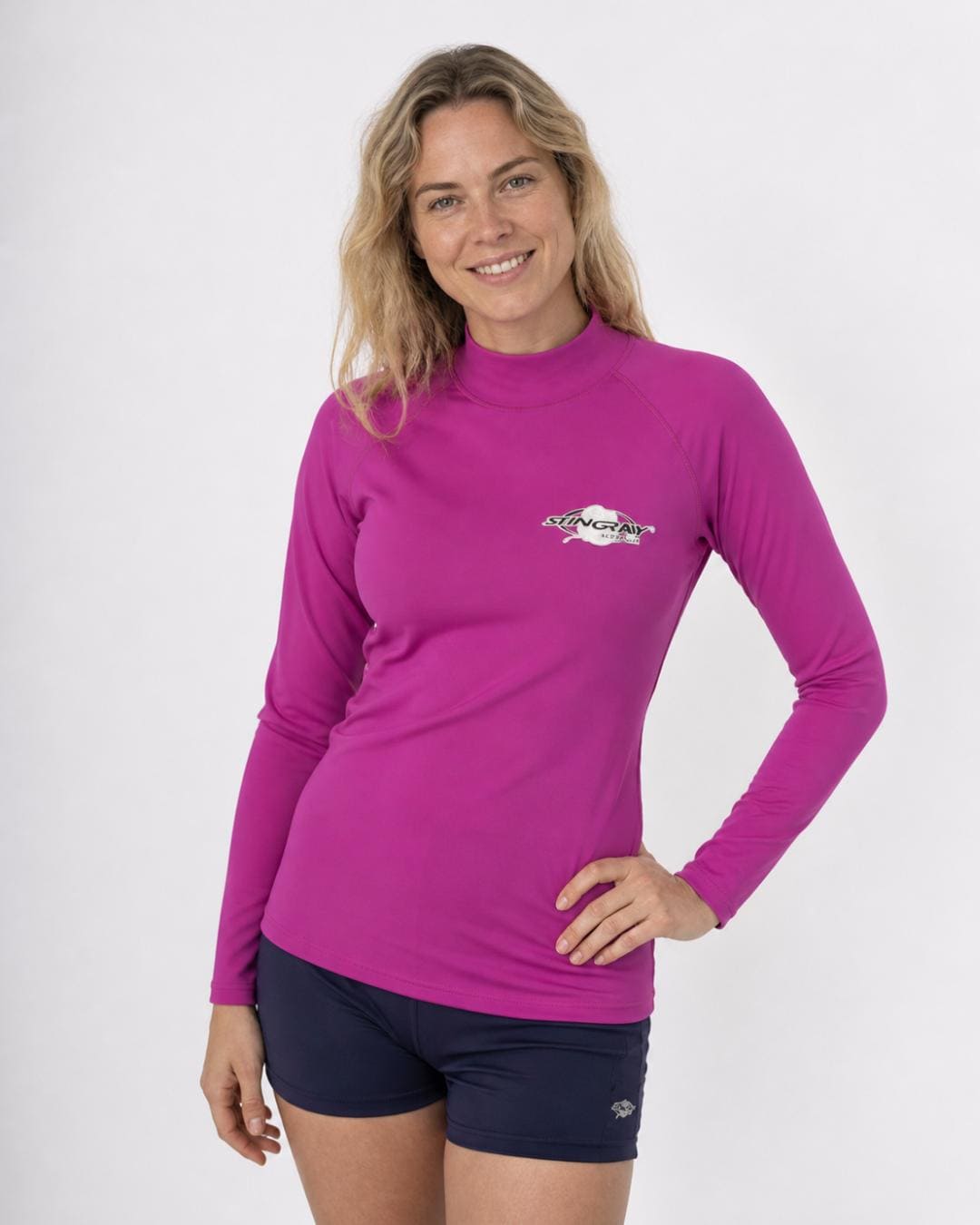 Woman wearing a purple long-sleeve UV rash vest UPF 50+ on a white background