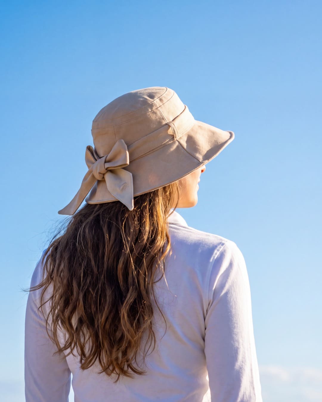 Womens Reversible UV Wide Brim Sun Hat UPF 50+ Desert Sand on Outside and Oatmeal on inside  Ribbon Desert Sand - Lifestyle of the back on model