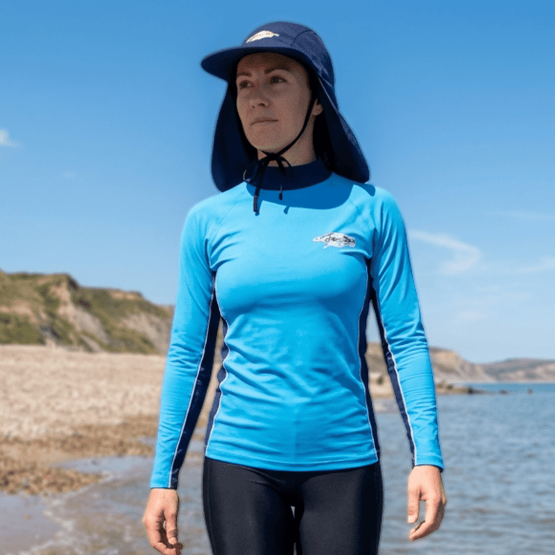 Woman wearing a UPF 50+ swim hat walking on the beach